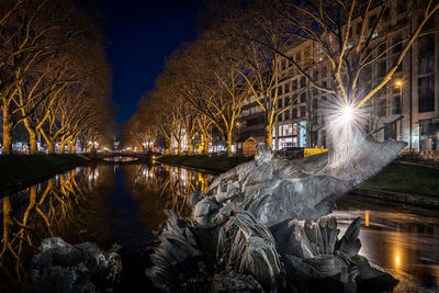 Triton fountain düsseldorf, view along a river and alley of trees