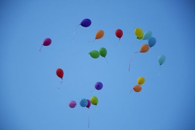 Low angle view of balloons against blue sky