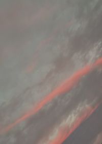 Low angle view of rainbow against dramatic sky