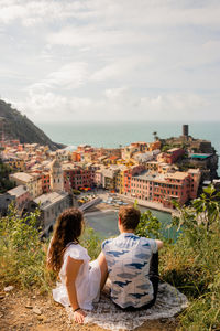 Rear view of people looking at cityscape against sky