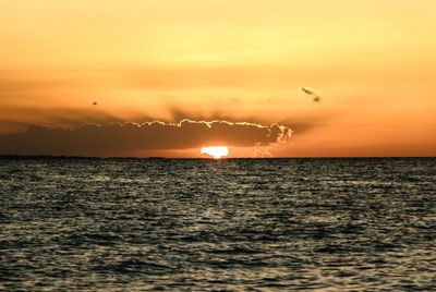 Scenic view of sea against orange sky