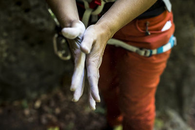 Midsection of woman rubbing sports chalk on hands
