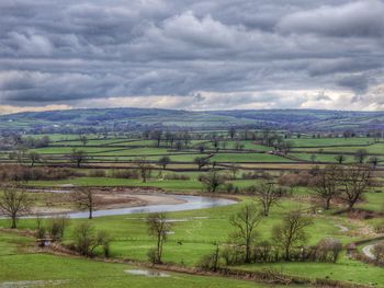 Scenic view of grassy field against cloudy sky