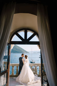 Full length of couple standing against sea