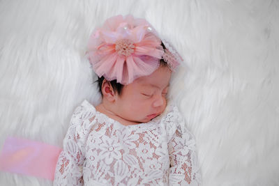 Cute newborn baby sleeps on white fluffy coverlets