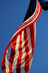 Low angle view of flag against clear blue sky