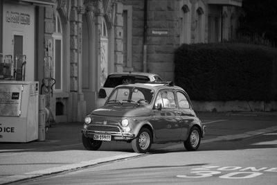 Car on street against buildings in city