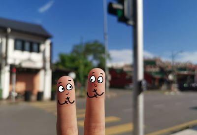 Close-up of human hand against the sky