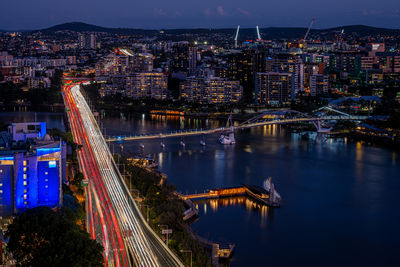 High angle view of illuminated bridge over river in city at night