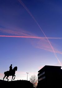 Low angle view of silhouette sculpture against sky