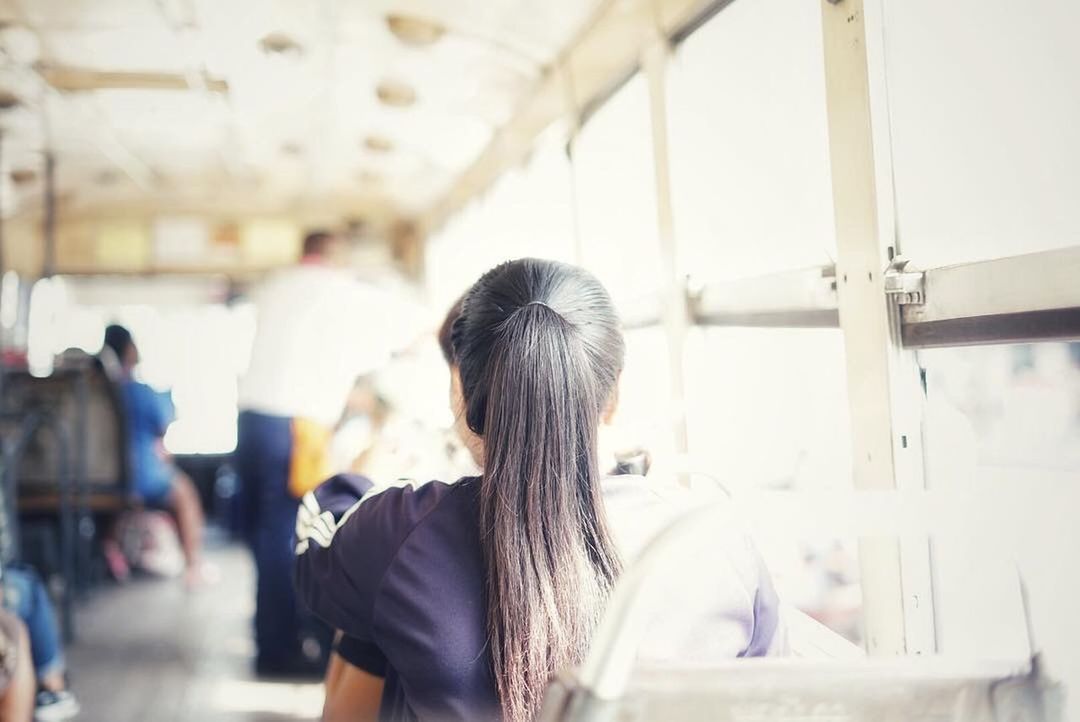 REAR VIEW OF WOMAN IN BUS