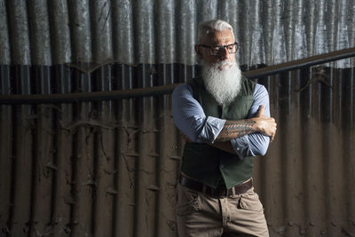 Portrait of man standing against wall