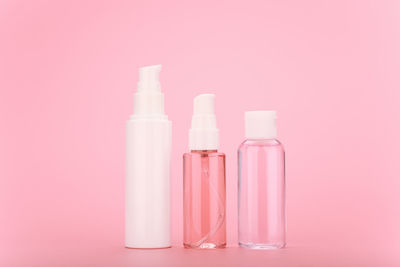 Close-up of bottles against pink background