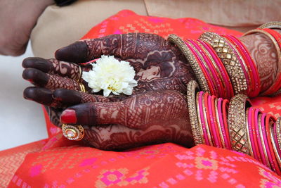 Close-up of woman holding red flowers