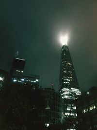 Low angle view of illuminated buildings against sky at night