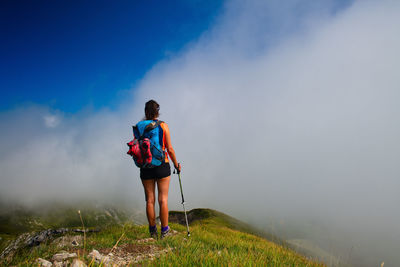 Rear view of man standing on landscape against sky