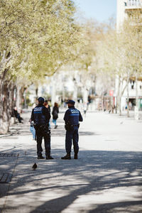 Rear view of people walking on street in city