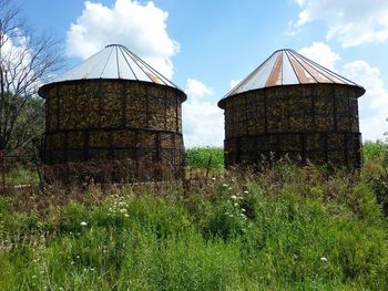 Built structure on field against cloudy sky