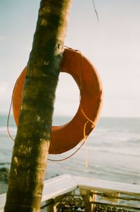 Close-up of wooden post in sea against sky