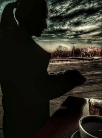 Side view of silhouette woman standing in front of building