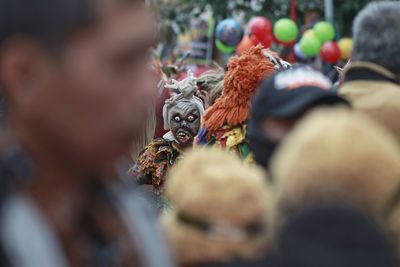 A teenager wears a scary indonesian ghost mask commonly called pocong in a cultural carnival