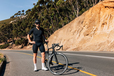 Rear view of man riding bicycle on road