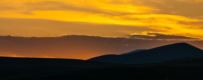 Scenic view of silhouette mountains against sky during sunset