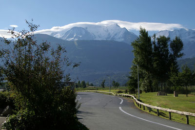 Scenic view of road by mountains against sky