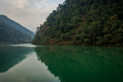 Scenic view of lake in forest at morning with reflection