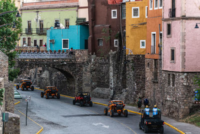 Vehicles on road by buildings in city