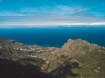 Scenic view of sea and mountains against sky