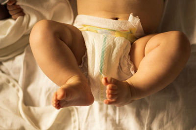Lower section of a baby wearing a diaper