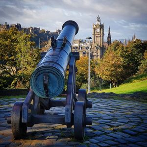 Metallic structure in city against cloudy sky