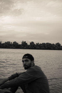 Portrait of man in lake against sky