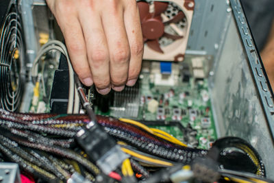 Cropped image of hand repairing mother board