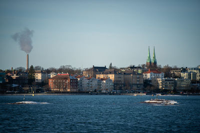 Distant view of st john church in city by sea against sky