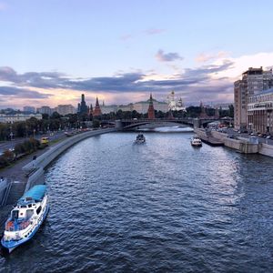 Boats in river with city in background