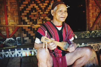 Senor man holding musical instrument