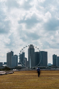 View of cityscape against cloudy sky