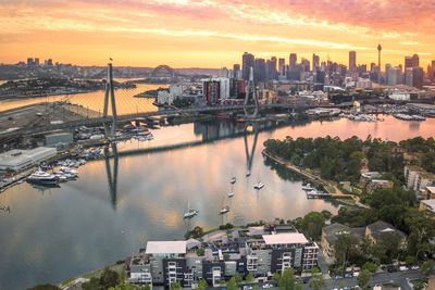 Aerial view of city at waterfront during sunset