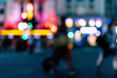 Defocused image of illuminated city street at night