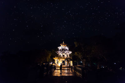 Illuminated traditional building against sky at night