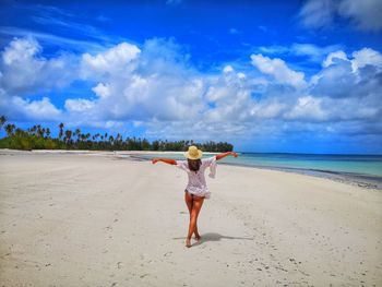 Rear view of woman walking at beach