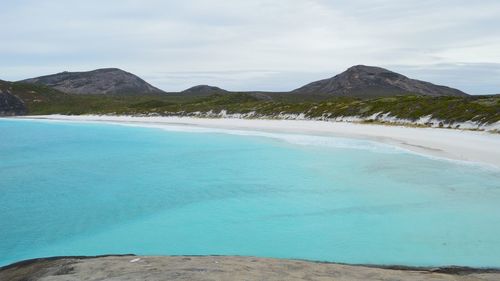 Scenic view of sea and mountains against sky
