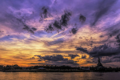 Scenic view of dramatic sky over river during sunset