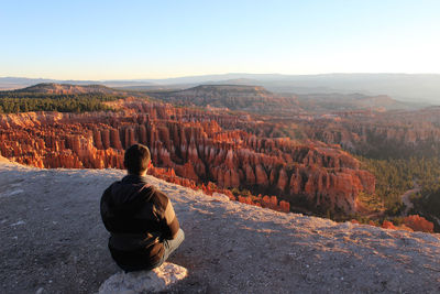 Rear view of man looking at mountain against sky