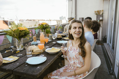 Portrait of smiling friends sitting on table