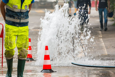 Manual worker wearing protective workwear while working on city street