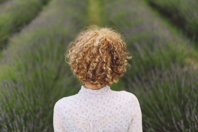 Rear view of woman standing on lavender field