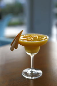 Close up shoot of fresh mango smoothie on martini glass served on the table